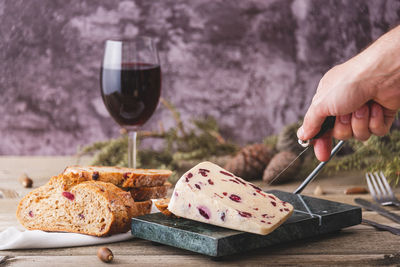 Wensleydale cheese with cranberries on a marble cheese cutting table.