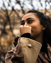 Side view of young woman using mobile phone