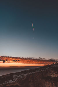 Scenic view of vapor trails in sky during sunset