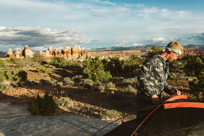 Camper dude sets up tent at sunset in the desert of utah