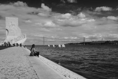 People on beach by sea against sky