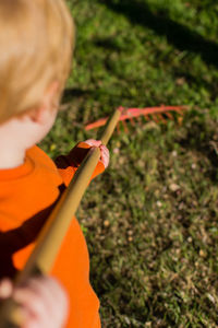 Rear view of boy holding umbrella on land
