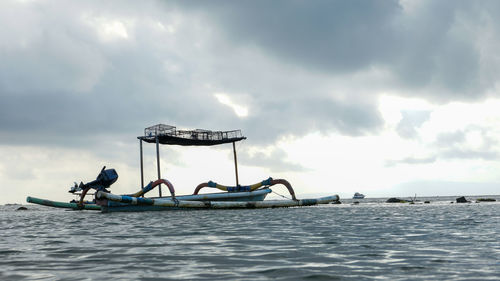 Fishing boat in sea against sky