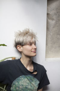 Portrait of boy looking away against wall at home