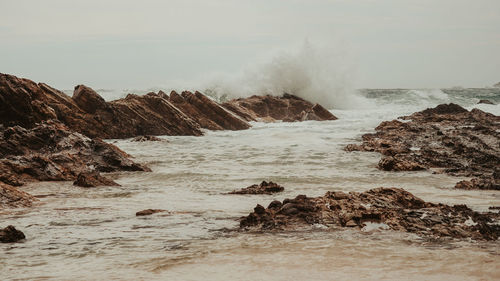 Rocks in sea against sky