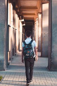 Young man walking in corridor at university