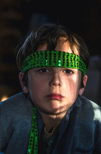 Close-up portrait of boy wearing green head band