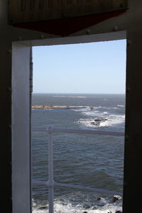 Scenic view of sea against clear sky seen through window