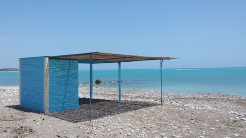 Lifeguard hut at beach against clear blue sky