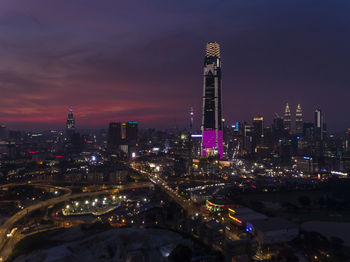 Illuminated buildings in city against sky at night