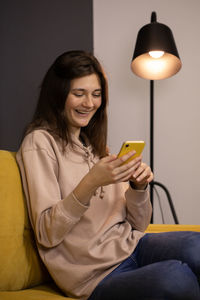 Young woman using mobile phone at home