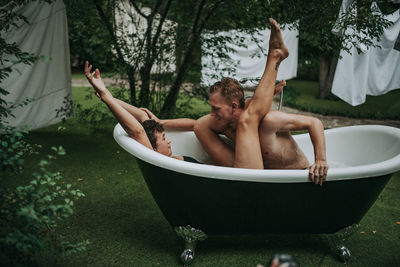 Full length of shirtless man in bathtub