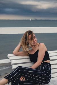 Portrait of young woman sitting at beach