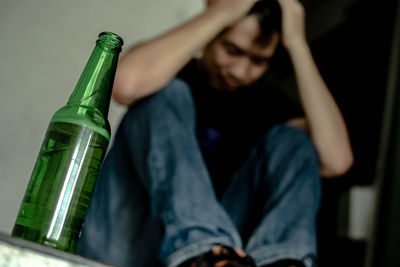 Midsection of man drinking beer in bottle