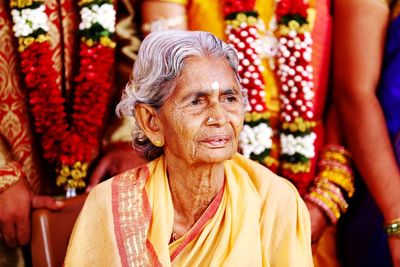 Senior woman in sari looking away while sitting on chair