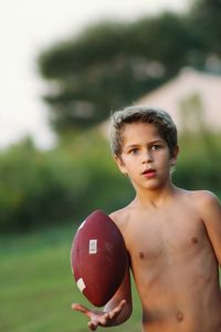 Portrait of shirtless boy holding ball