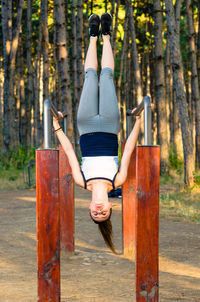 Full length of woman with arms raised in forest