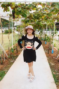 Portrait of smiling young woman standing against trees