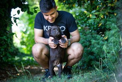 Man with dog sitting on plants