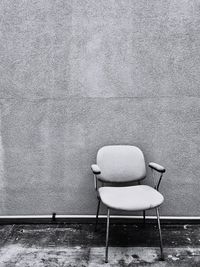 Empty chair on table against wall in snow