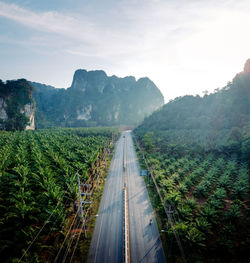 Empty road amidst mountains against sky