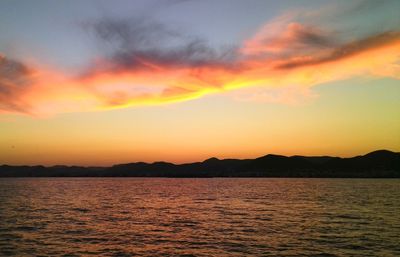 Scenic view of sea against dramatic sky during sunset