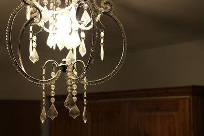 Low angle view of illuminated chandelier hanging on ceiling