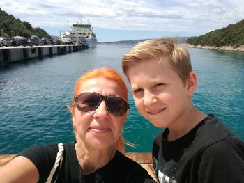 Portrait of grandmother and grandson against sea