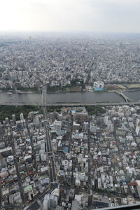 High angle view of cityscape by river against sky