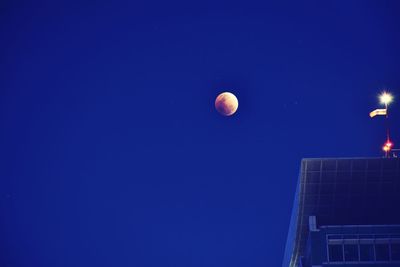 Low angle view of moon against clear blue sky