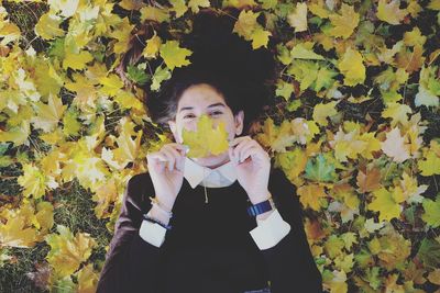 Portrait of teenage girl holding autumn leaves