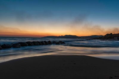 Scenic view of beach against sky during sunset