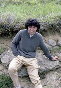 Side view of woman sitting on field