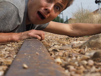 Portrait shocked man on abandoned railroad track