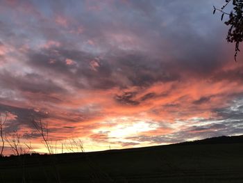 Silhouette landscape against dramatic sky during sunset