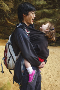 Portrait of a happy father with his little girl tucked inside his coat