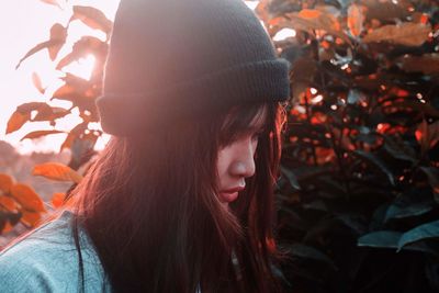 Close-up portrait of young woman with leaves