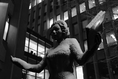 Low angle view of statue against building in city