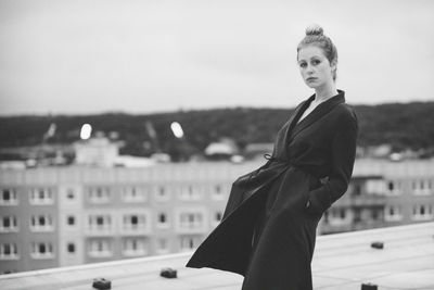 Portrait of woman standing against clear sky in city