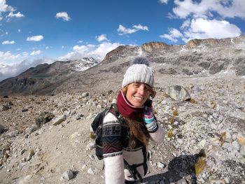 Portrait of smiling young woman standing on mountain
