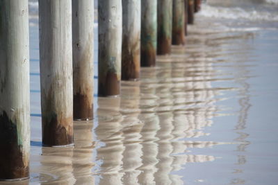 Reflection of wooden posts in water