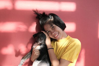 Portrait of a smiling young woman with dog