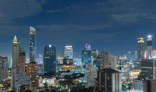 Illuminated buildings in city against sky