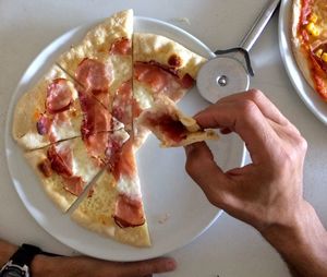 Close-up of hand holding ice cream in plate