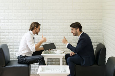 Businessmen discussing while sitting at table in office