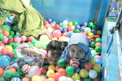 High angle view of sisters playing in ball pool