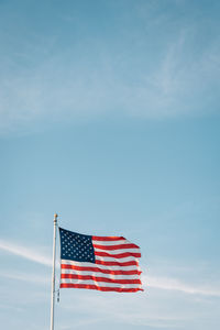 Low angle view of flag against blue sky