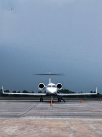 Airplane on runway against sky