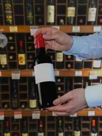 Close-up of hand holding wine bottles