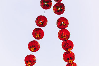 Low angle view of lanterns hanging against white background